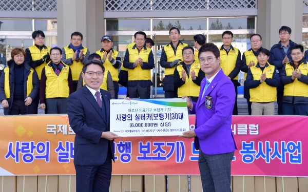 △ 여수시청 현관에서 권오봉 여수시장이 주효성 중앙로타리클럽 회장(오른쪽)으로부터 성인용 보행기 후원증서를 받고 있다.