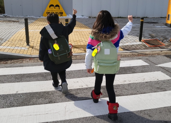 학생들이 충남교육청이 보급한 ‘옐로카드’를 가방에 부착하고 건널목을 건너고 있다.(사진=충남교육청)