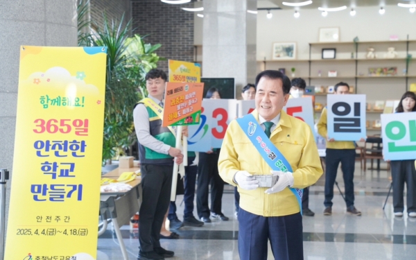 7일 김지철 교육감을 비롯한 간부 직원들이 안전 어깨띠를 착용하고 도교육청 중앙현관에서 세월호 추모를 위한 노란리본 배지를 나눠주고 있다.(사진=충남교육청)